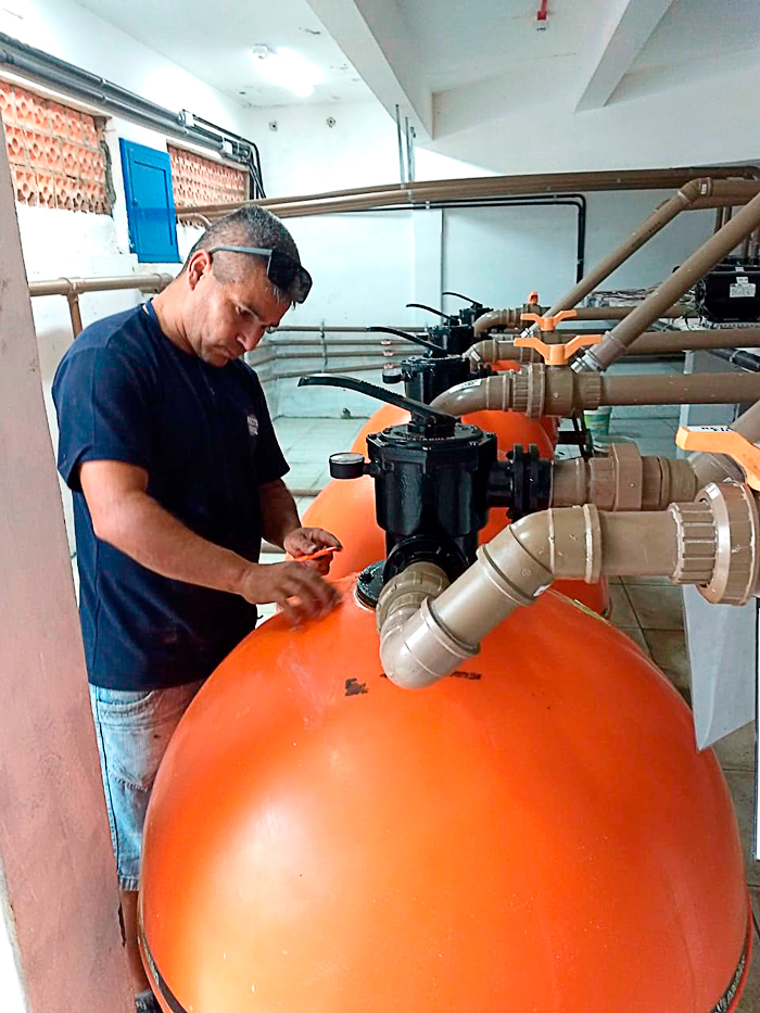 Profissional verificando válvula seletora e filtro de piscina