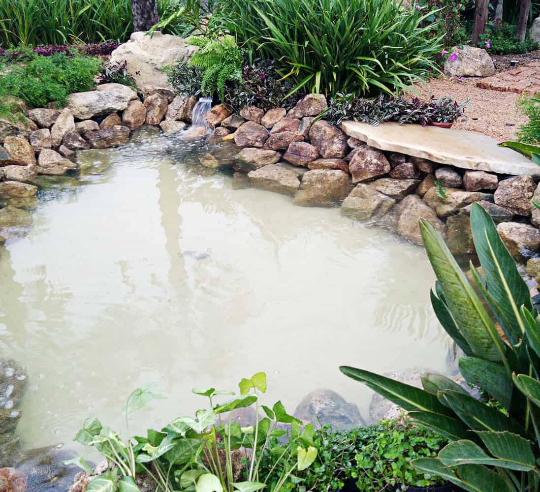 Queda d'água integrada a pedras e vegetação