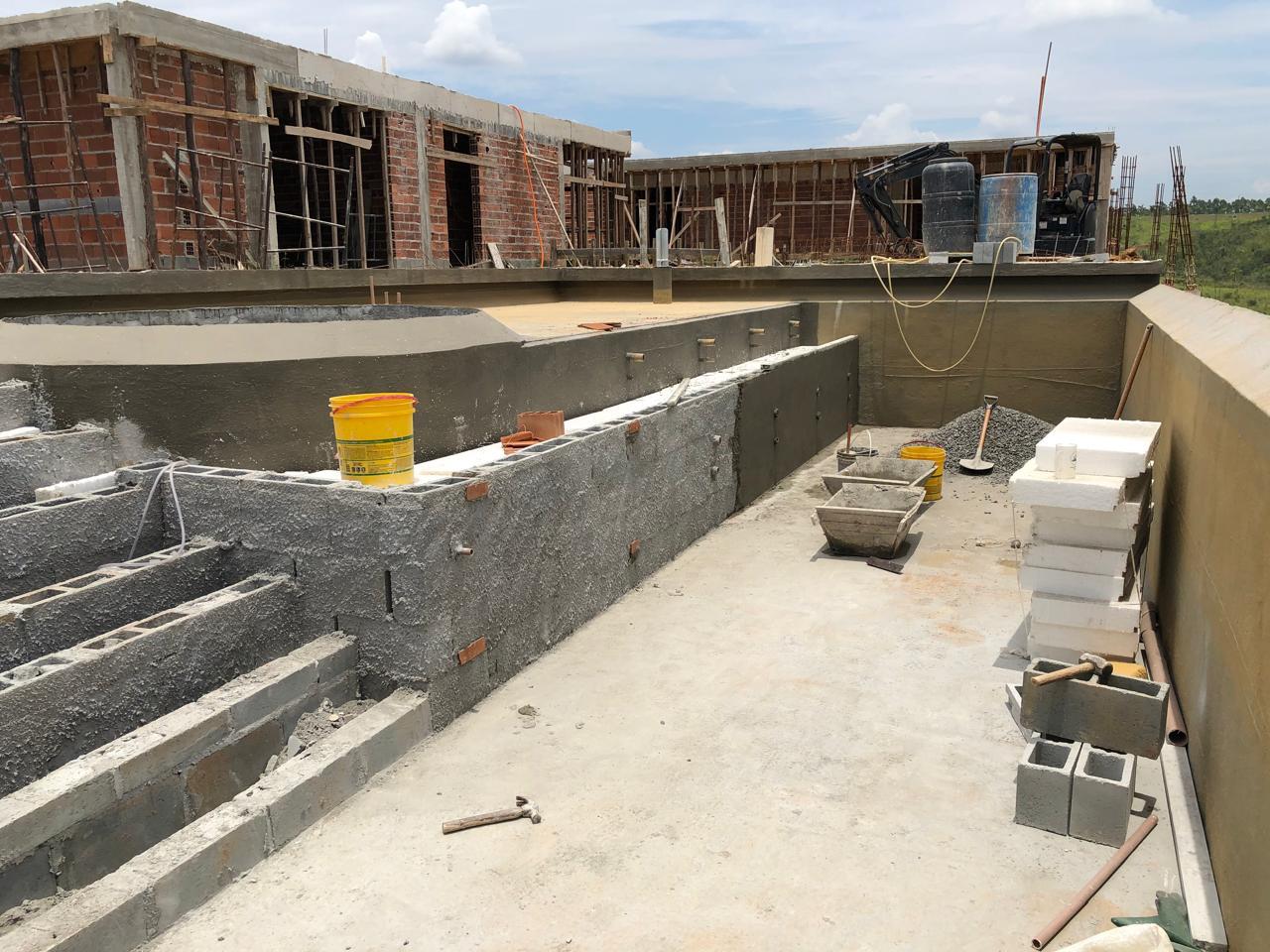 Piscina em obra com sistema de impermeabilização e interfaces hidráulicas em execução