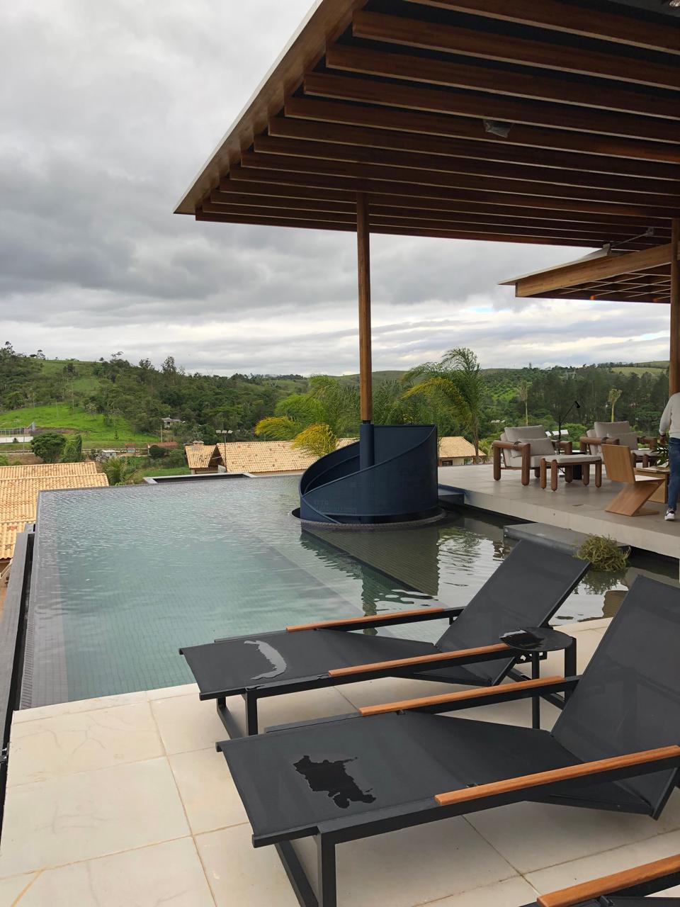 Piscina real de alto padrão com borda infinita integrada à arquitetura residencial